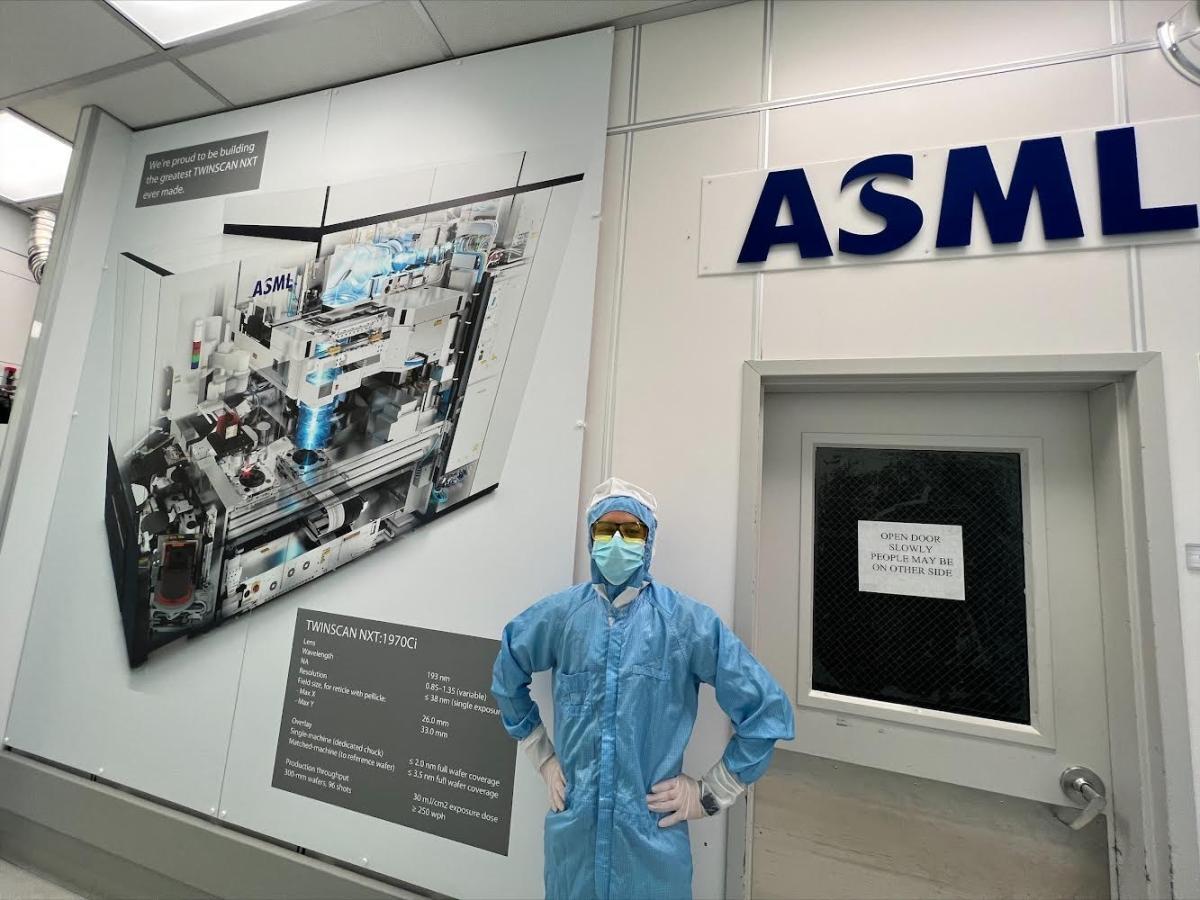 Student standing in an ASML lab wearing full protection gear